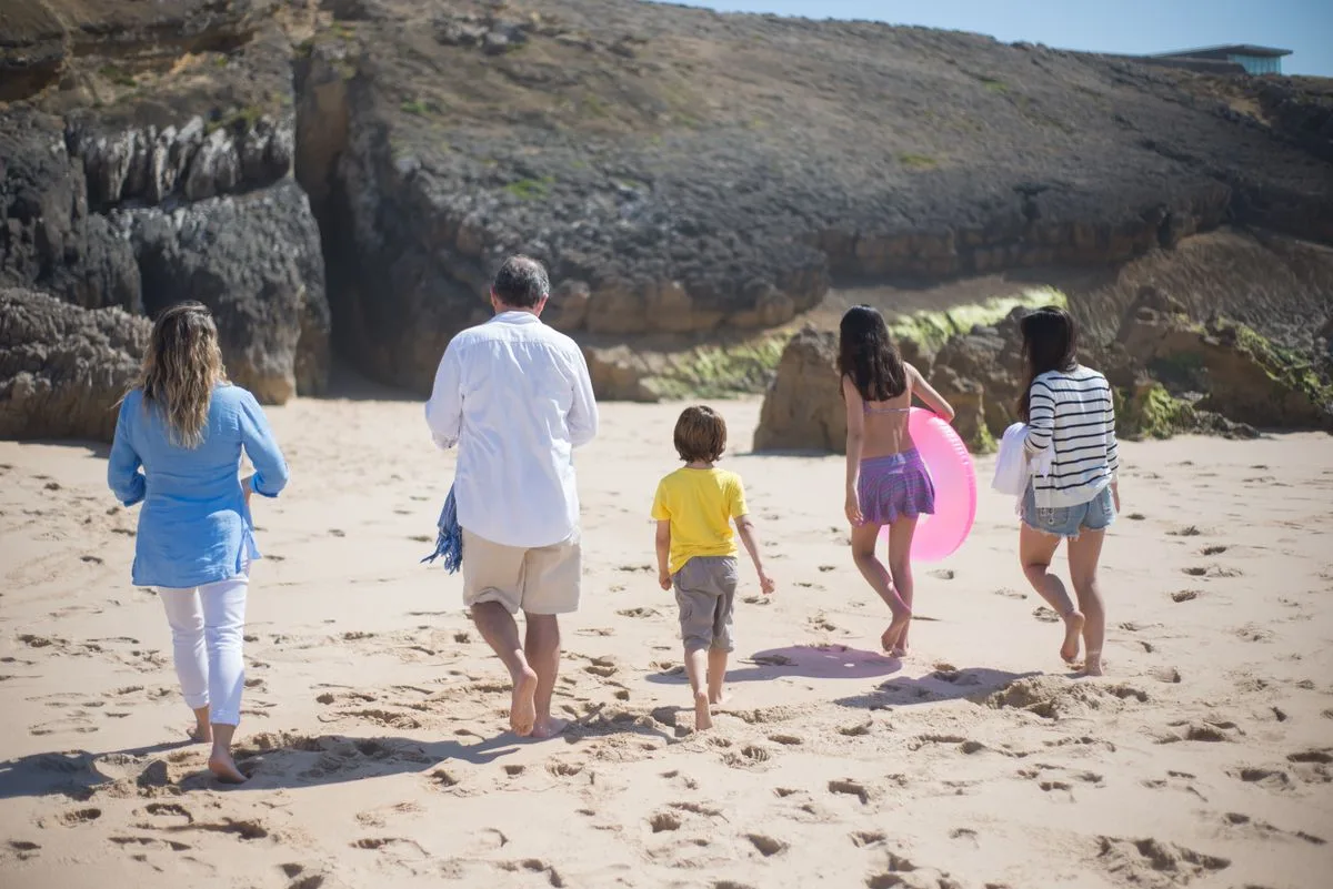 Family walking together on a sunny Portuguese beach.